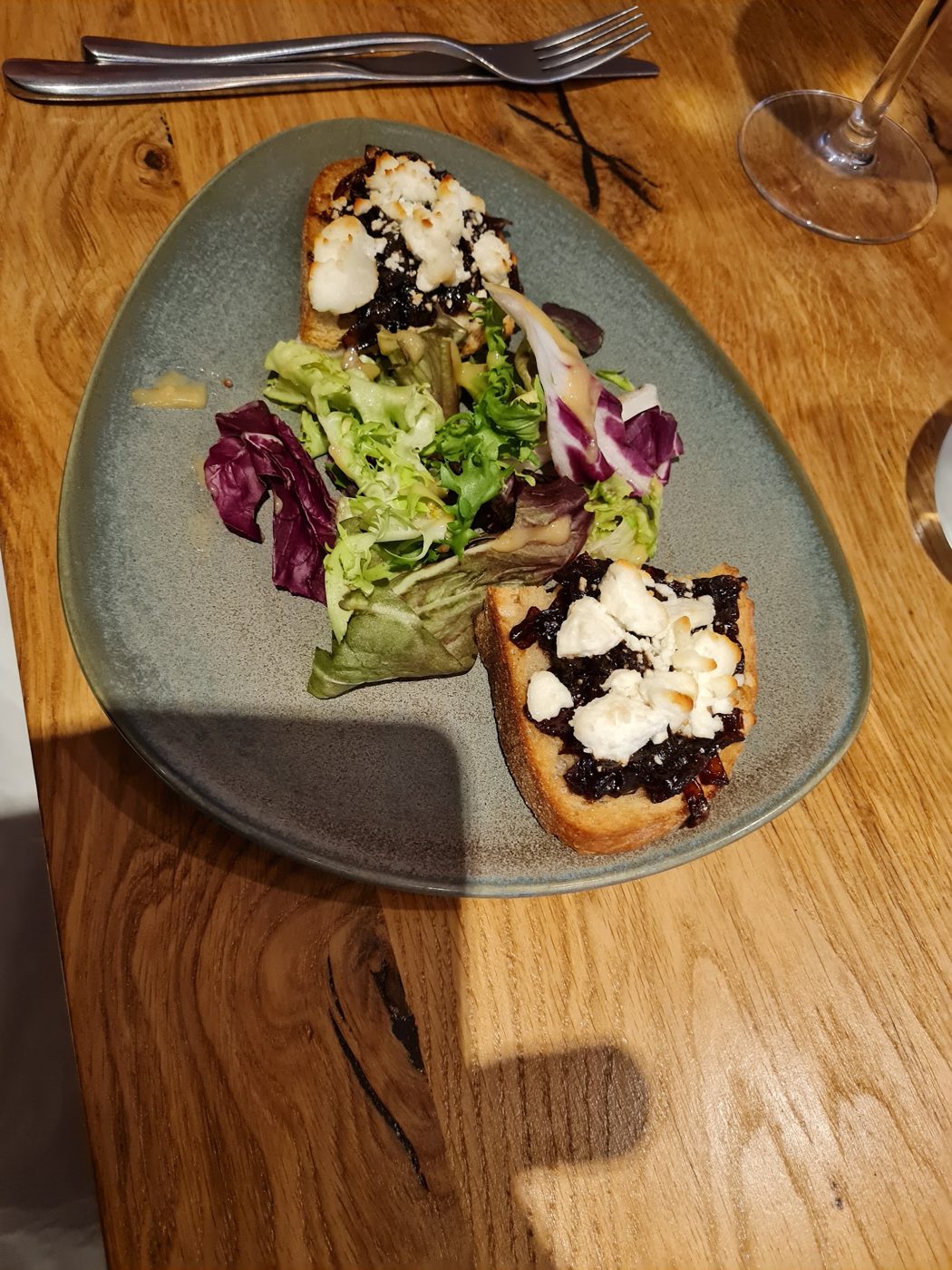 Bruschetta with dressed leaves on a grey plate