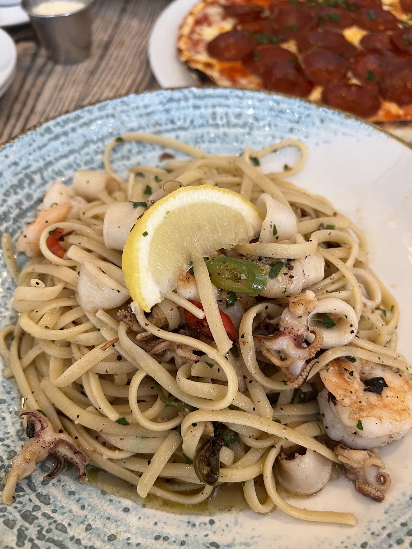 Seafood linguine with prawns, squid and a lemon wedge
