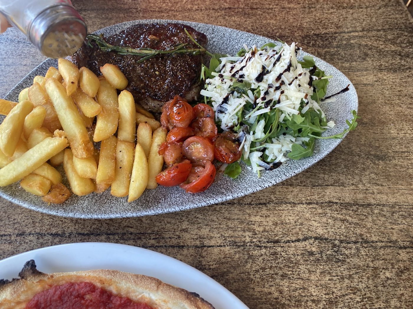 Steak with chips, cherry tomatoes and rocket salad