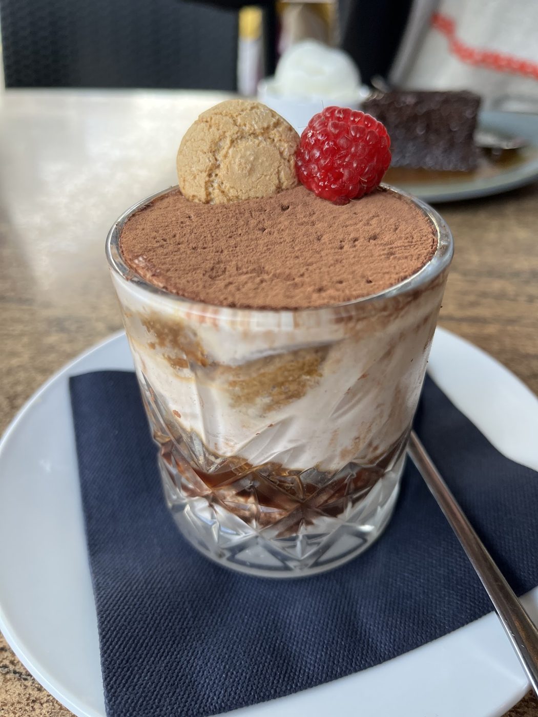 Tiramisu in a glass with a raspberry and an amaretti biscuit